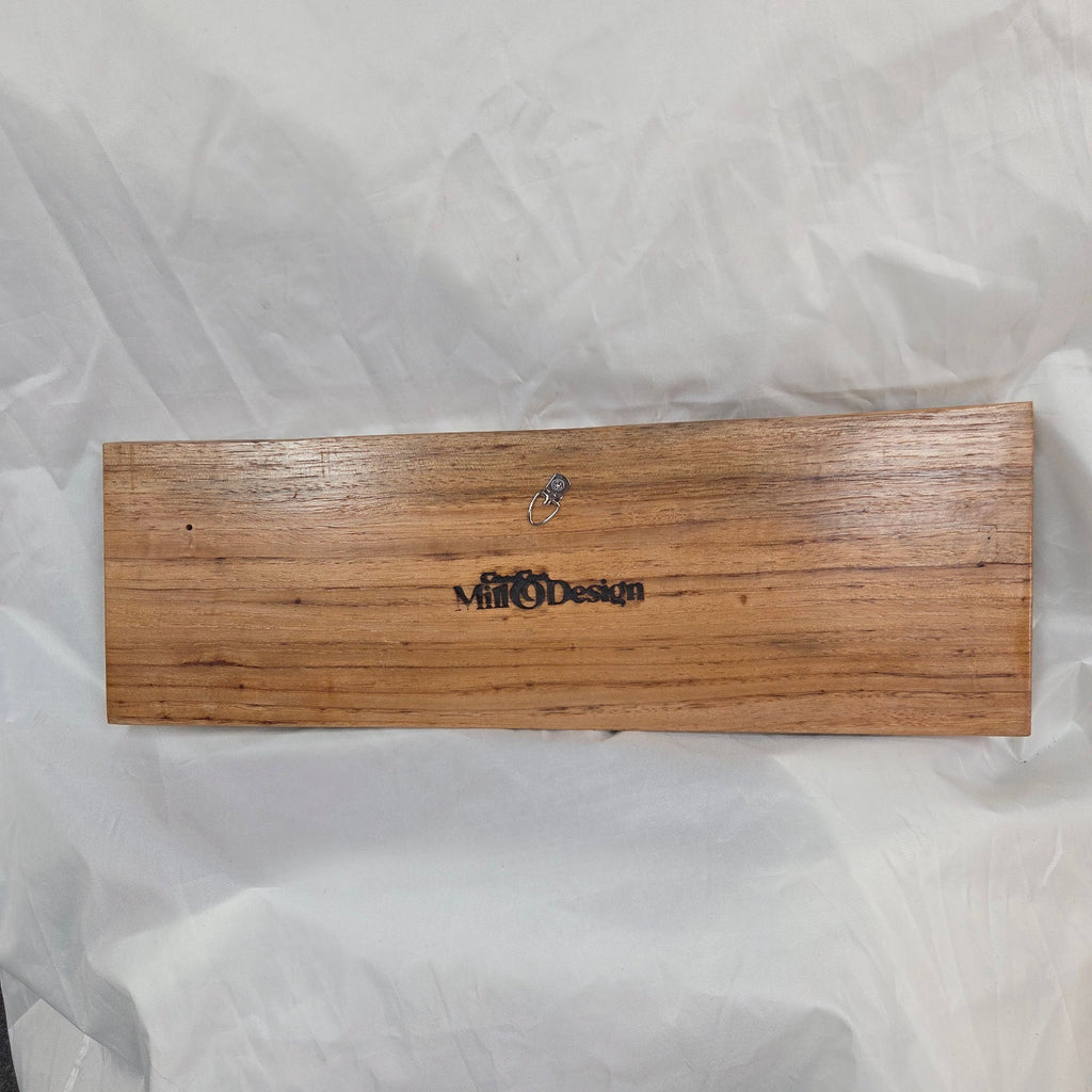 A rustic rectangular pecan sign with the word 'HOWDY' hand carved in dark brown burnt lettering,