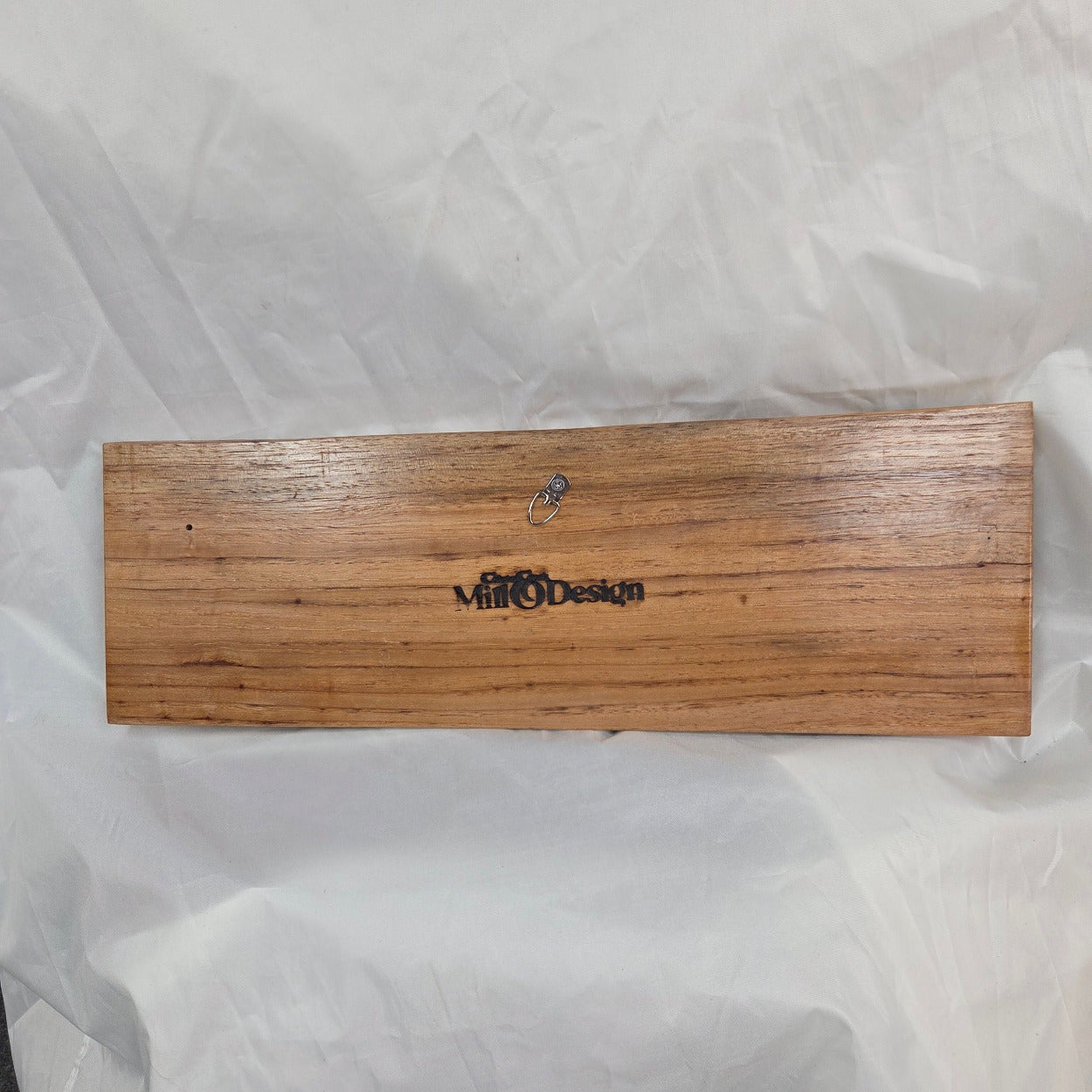 A rustic rectangular pecan sign with the word 'HOWDY' hand carved in dark brown burnt lettering,