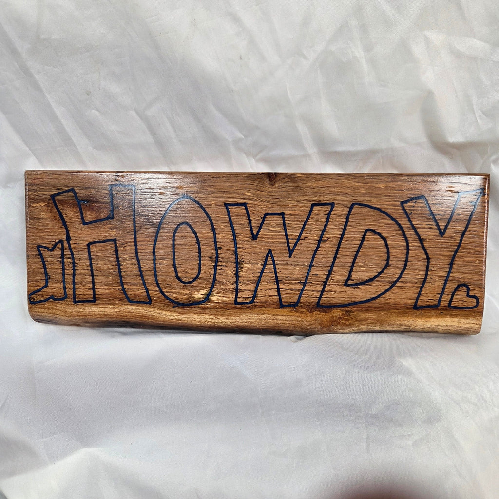 A rectangular white oak sign with a natural brown wood grain finish, featuring the word 'HOWDY' cut out in blue epoxy outline lettering, 