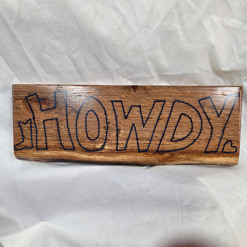 A rectangular white oak sign with a natural brown wood grain finish, featuring the word 'HOWDY' cut out in blue epoxy outline lettering, 