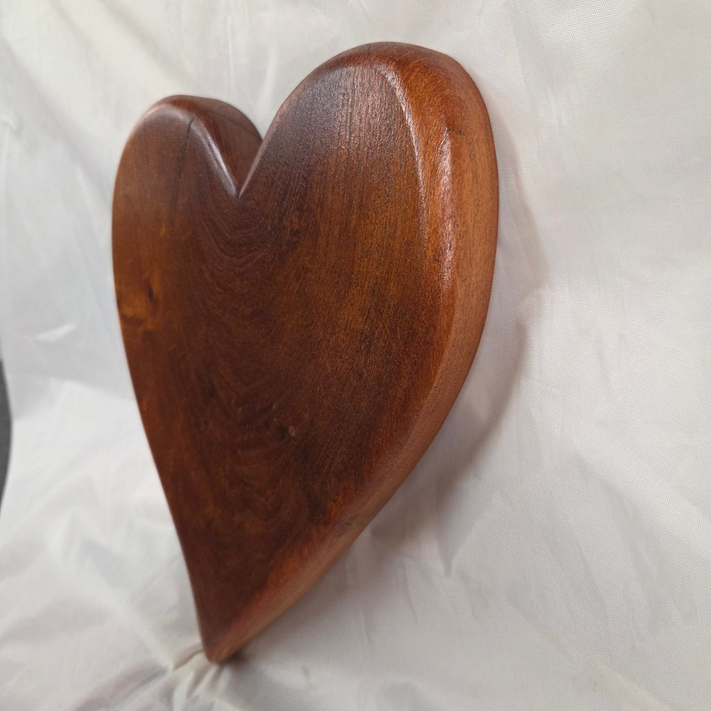 A heart-shaped mesquite wall art with a polished finish, showcasing natural wood grain