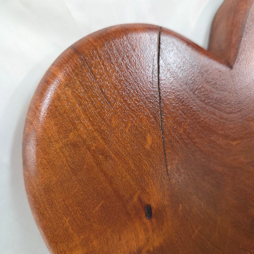 close up view A heart-shaped mesquite wall art with a polished finish, showcasing natural wood grain