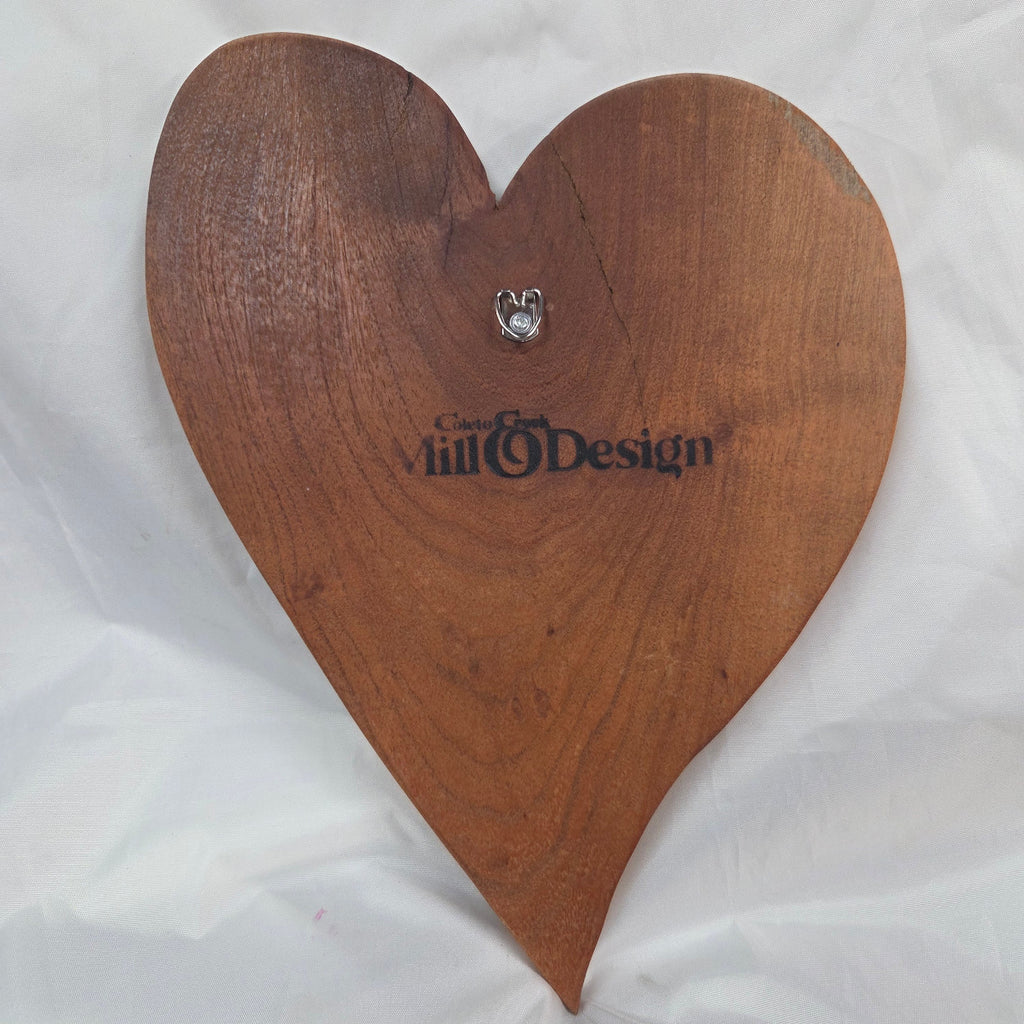 back view of A heart-shaped mesquite wall art with a polished finish, showcasing natural wood grain