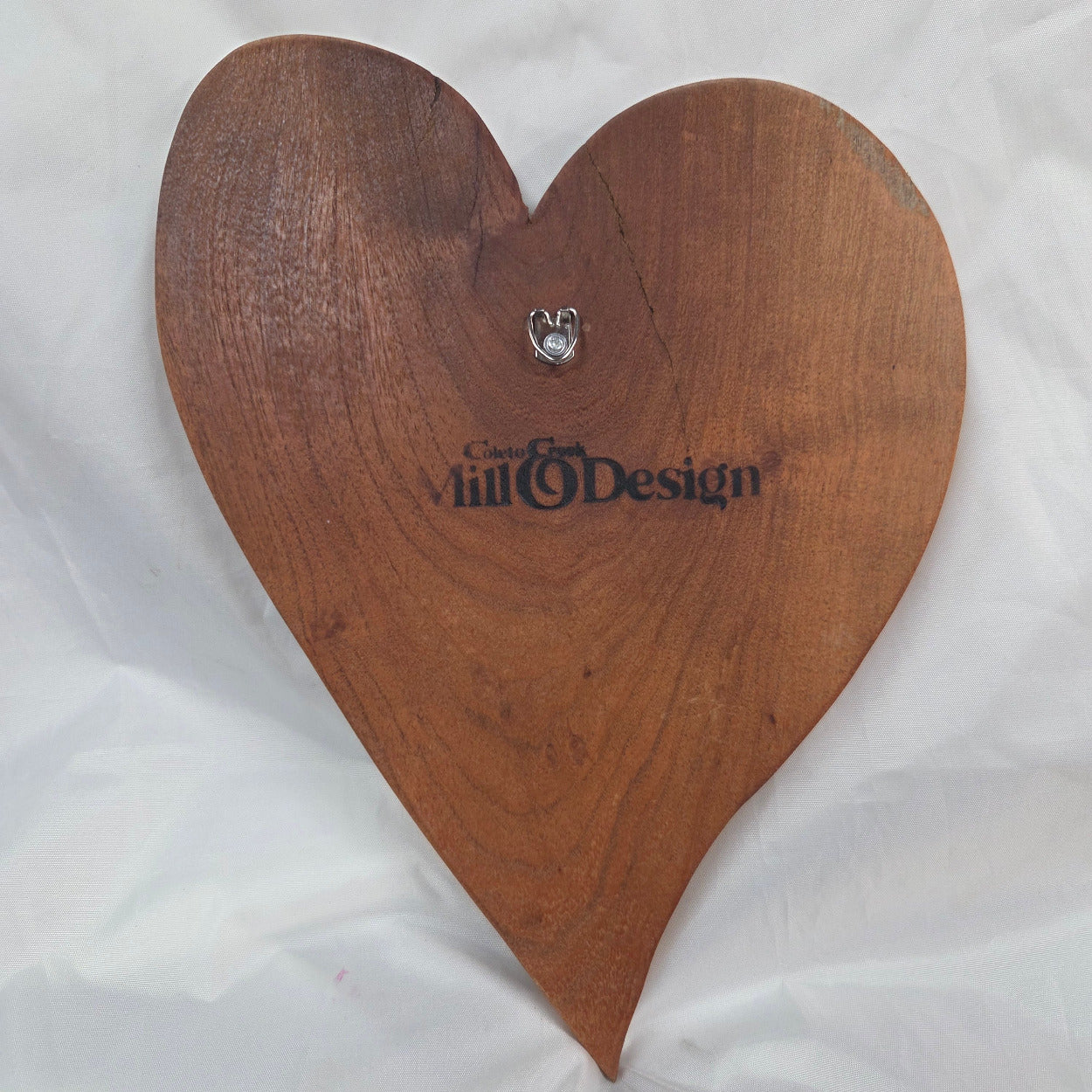 back view of A heart-shaped mesquite wall art with a polished finish, showcasing natural wood grain