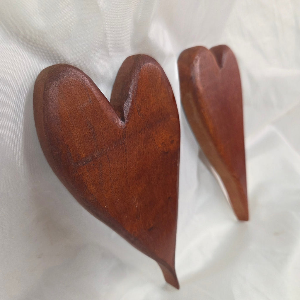A pair of heart-shaped mesquite wall art with a polished finish, showcasing natural wood grain