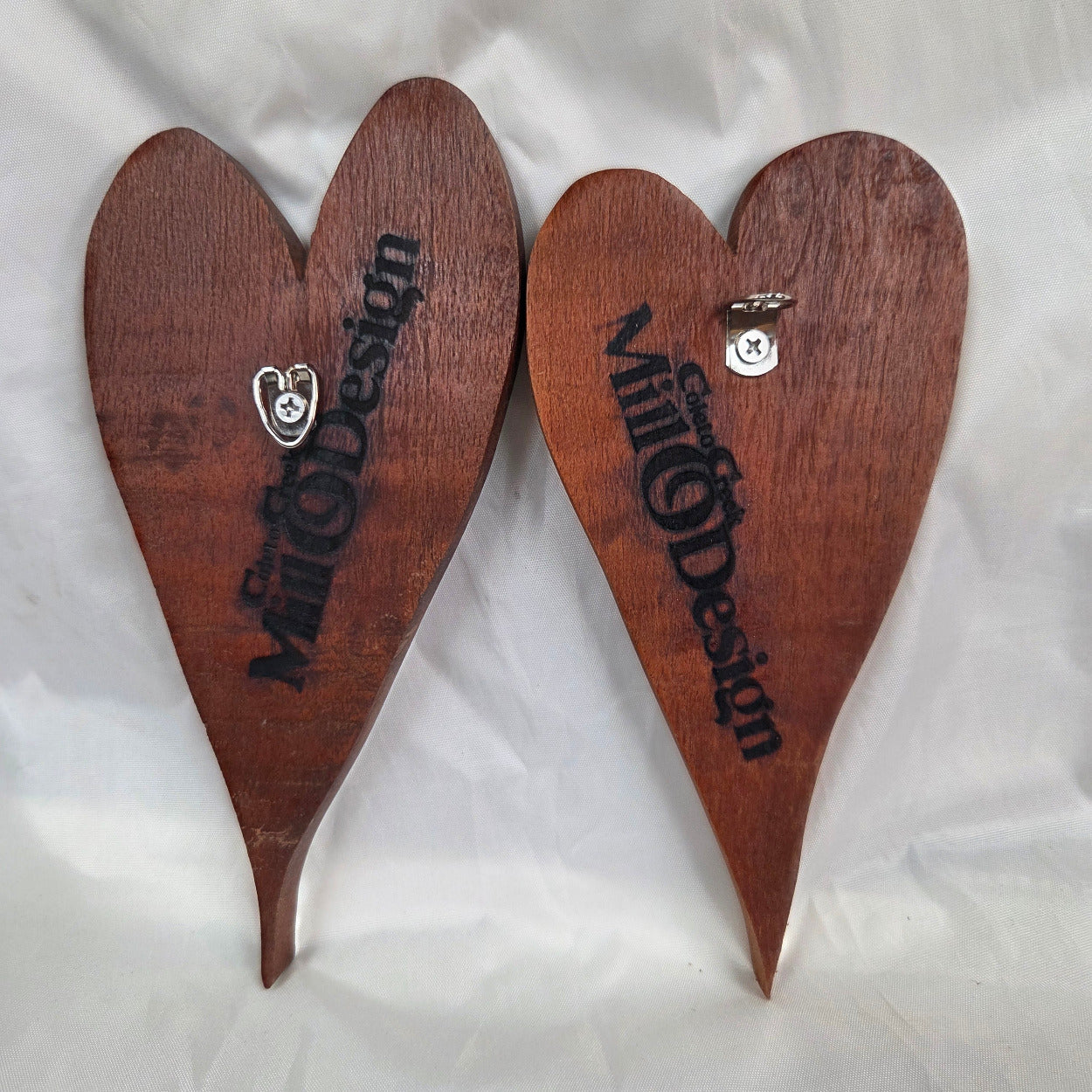 back view of A pair of heart-shaped mesquite wall art with a polished finish, showcasing natural wood grain