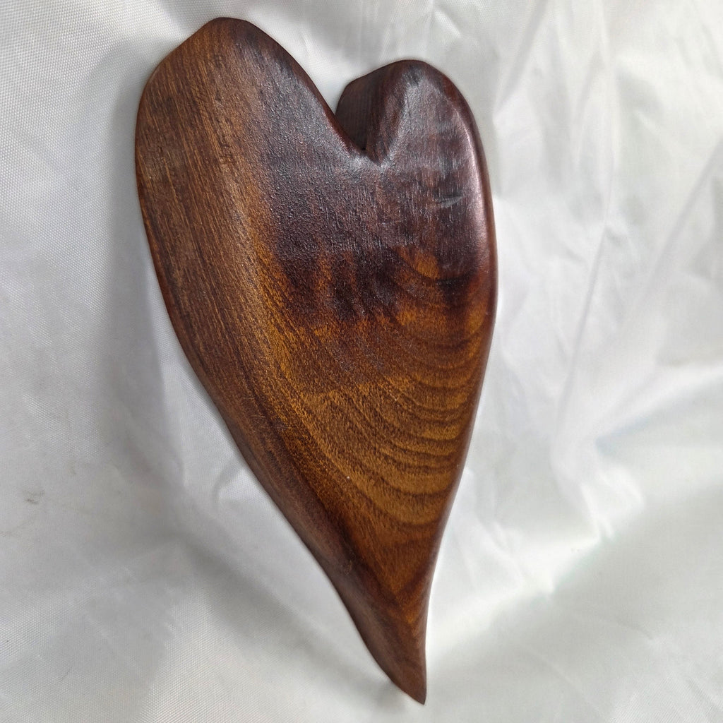 A heart-shaped mesquite wall art with a polished finish, showcasing natural wood grain