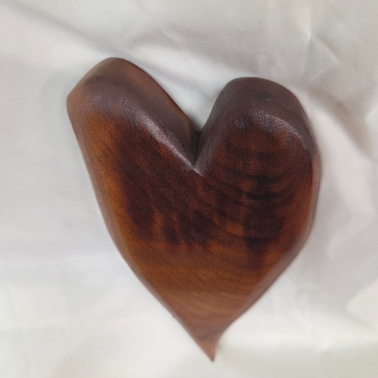 A heart-shaped mesquite wall art with a polished finish, showcasing natural wood grain