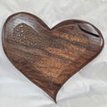 A hand carved heart-shaped White Oak Hanging heart wall art with a carved pattern in the center, photographed on a wrinkled white background.