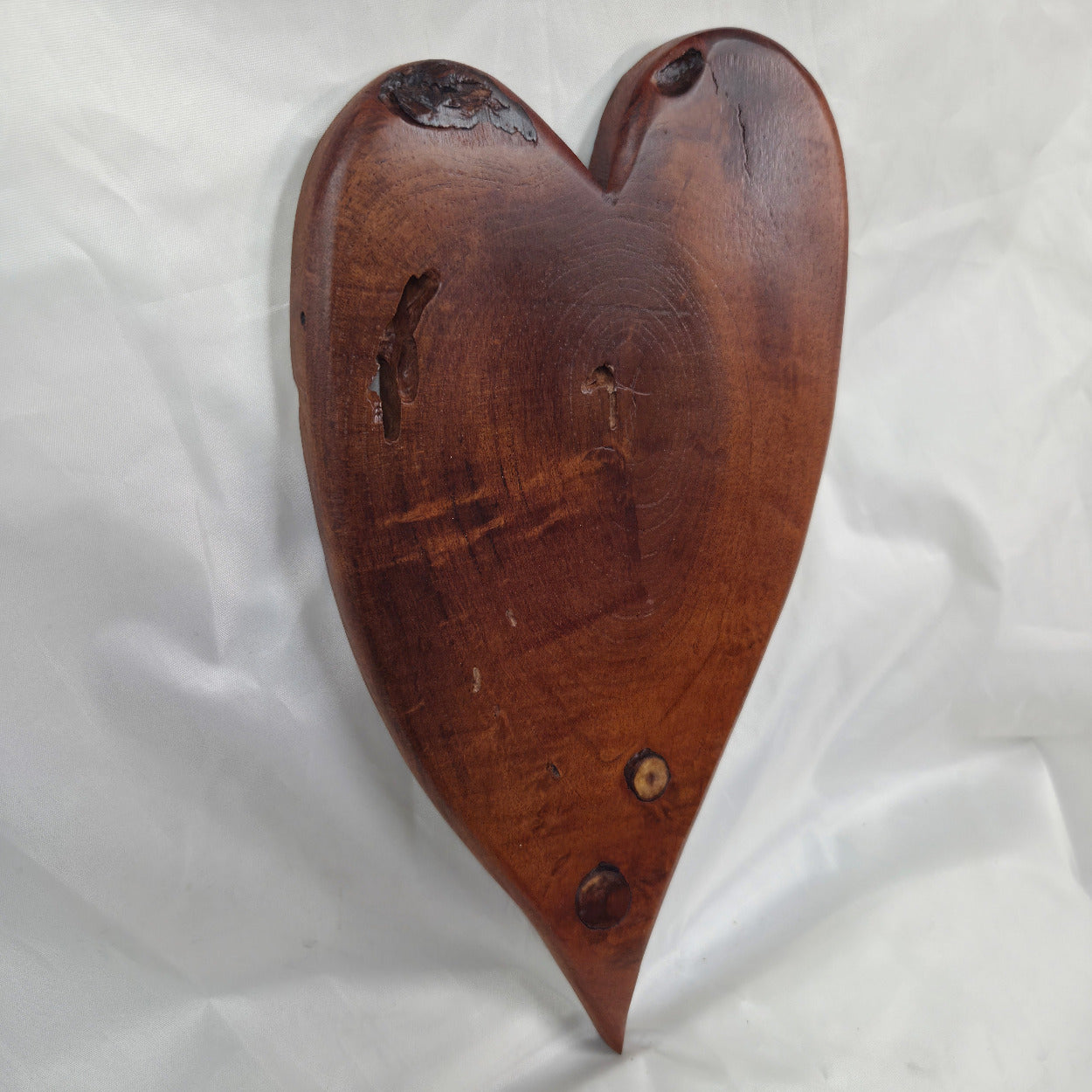 A heart-shaped Mesquite wall plaque with natural live edges and visible wood grain