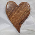 A heart-shaped White Oak Handing Heart wall art with a glossy finish and prominent natural wood grain, resting on a white fabric background.