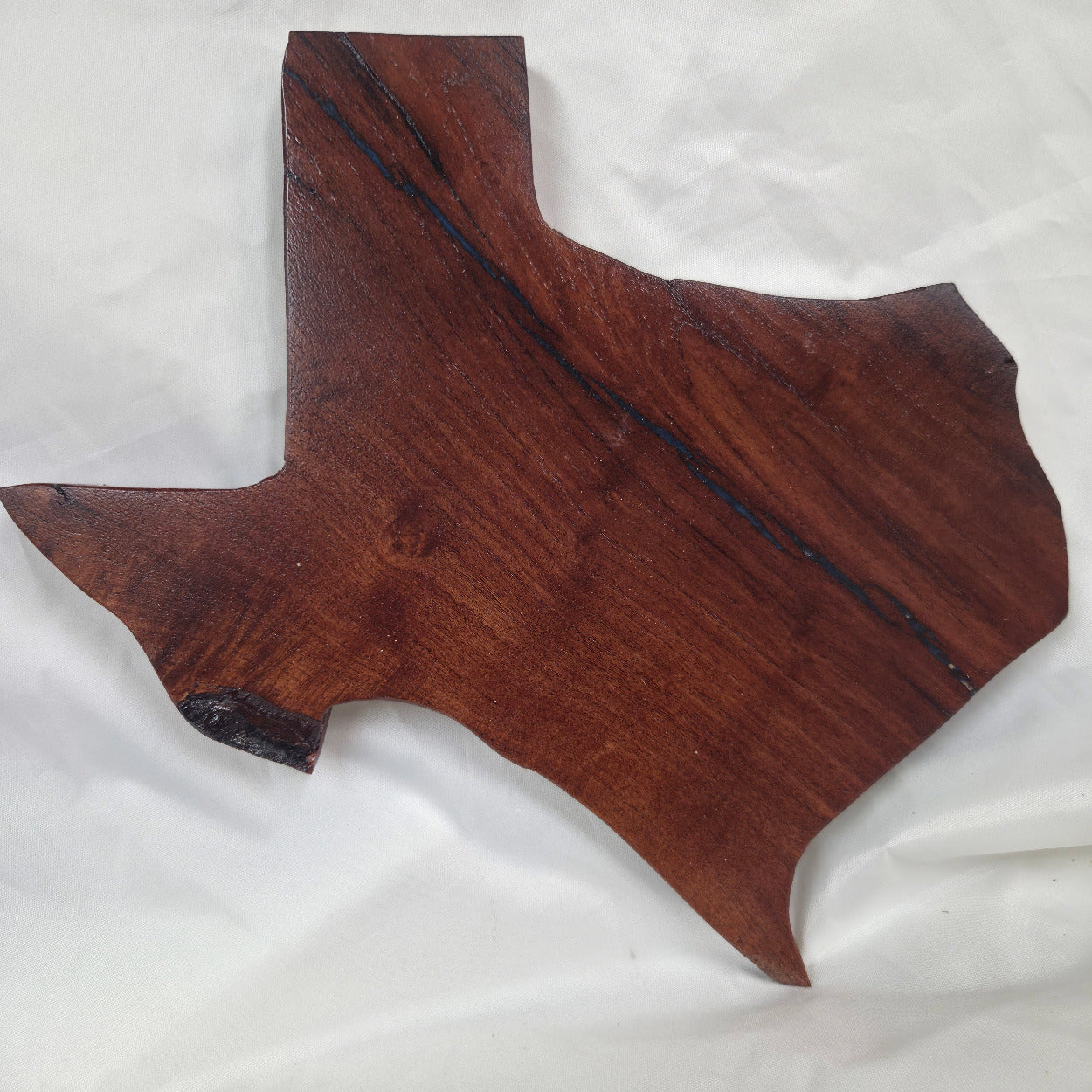 A carved mesquite wall plaque shaped like the state of Texas, with Blue epoxy fill and semi-gloss finish