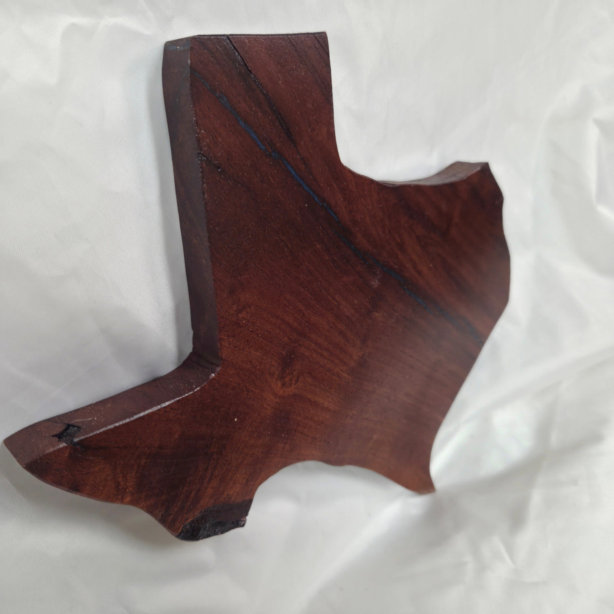 A carved mesquite wall plaque shaped like the state of Texas, with Blue epoxy fill and semi-gloss finish