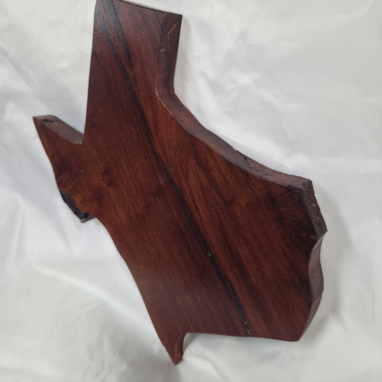 A carved mesquite wall plaque shaped like the state of Texas, with Blue epoxy fill and semi-gloss finish