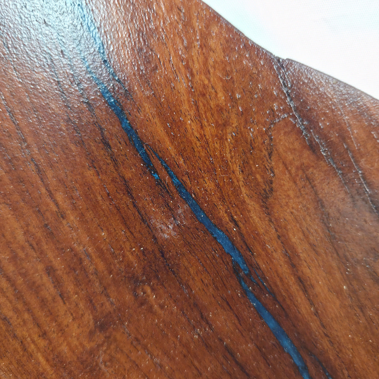 close up A carved mesquite wall plaque shaped like the state of Texas, with Blue epoxy fill and semi-gloss finish
