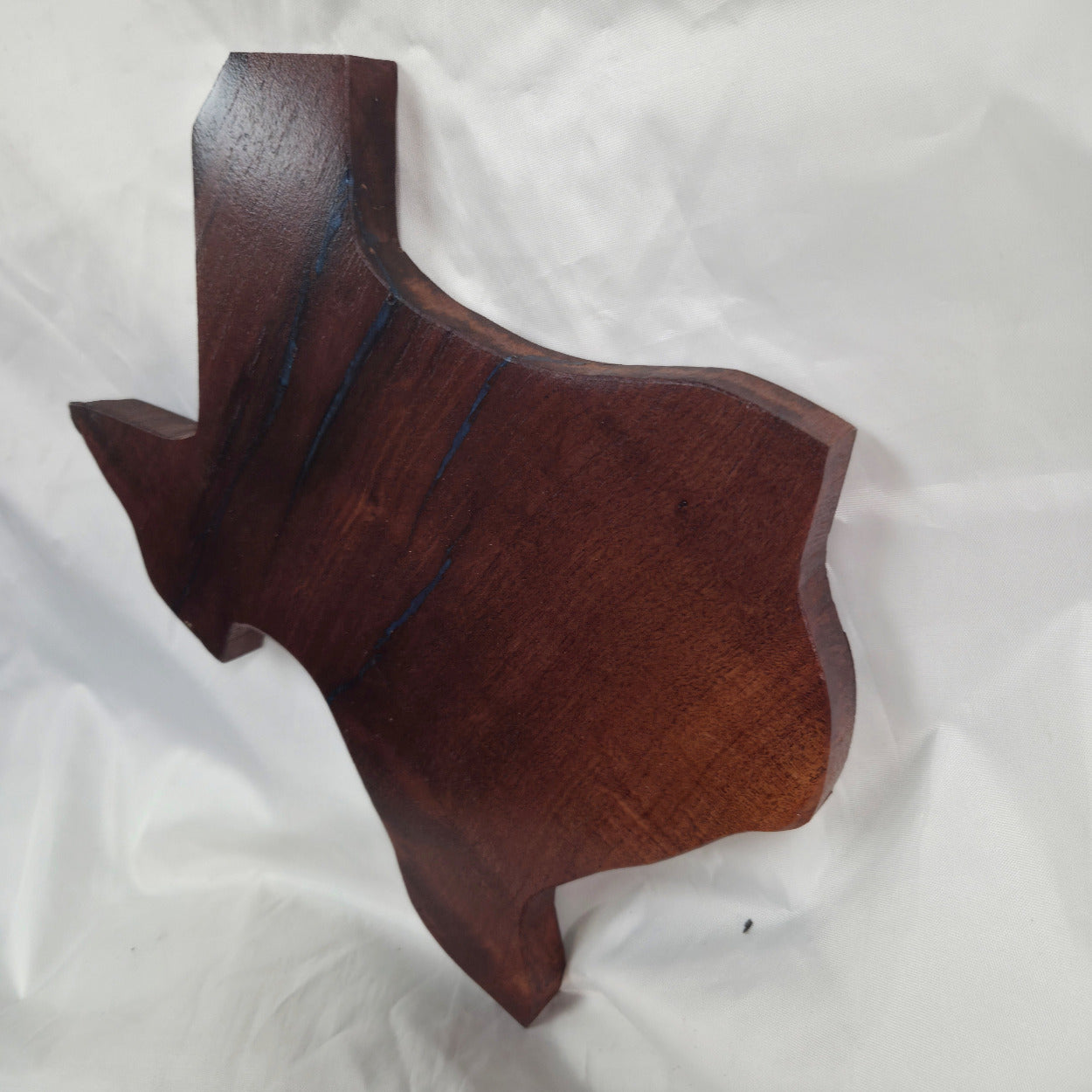 A carved mesquite wall plaque shaped like the state of Texas, with Blue epoxy fill and semi-gloss finish