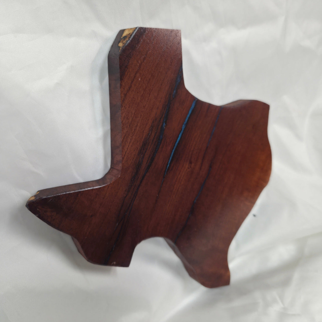 A carved mesquite wall plaque shaped like the state of Texas, with Blue epoxy fill and semi-gloss finish