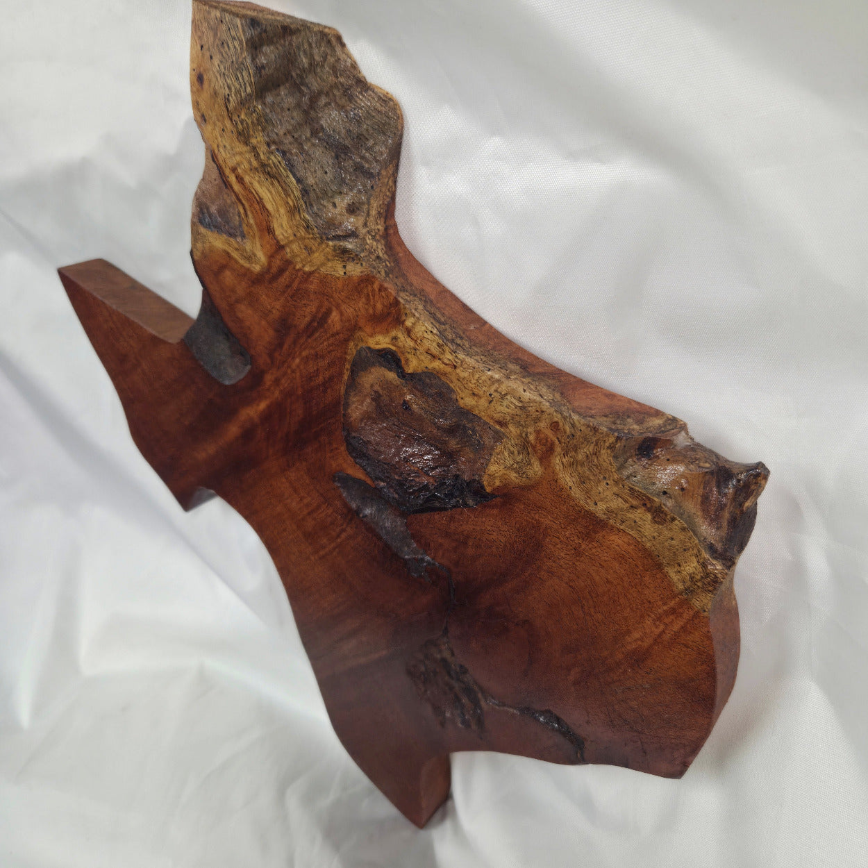 A rustic Texas-shaped wall art plaque made from mesquite wood with a dark, textured natural with natural deformities