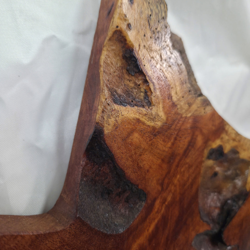 close up A rustic Texas-shaped wall art plaque made from mesquite wood with a dark, textured natural with natural deformities