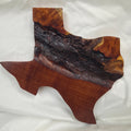 A rustic Texas-shaped wall art plaque made from mesquite wood with a dark, textured natural bark-like band running diagonally across the center, 