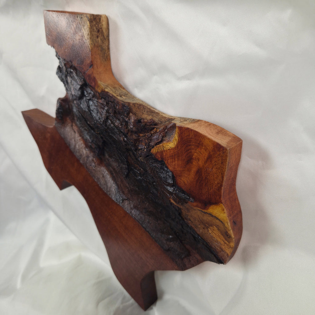 A rustic Texas-shaped wall art plaque made from mesquite wood with a dark, textured natural bark-like band running diagonally across the center, 
