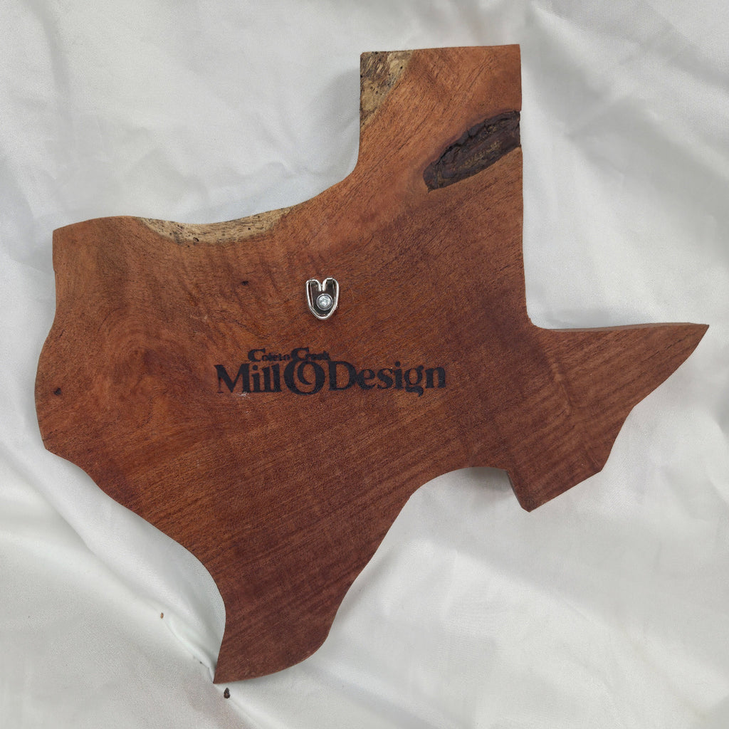 back view A rustic Texas-shaped wall art plaque made from mesquite wood with a dark, textured natural bark-like band running diagonally across the center, 