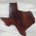 A rustic, hand-shaped wooden plaque wall art in the shape of Texas, made from mesquite wood with natural grain, dark burn marks and blue epoxy fill