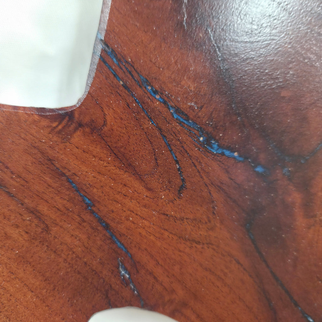 close up A rustic, hand-shaped wooden plaque wall art in the shape of Texas, made from mesquite wood with natural grain, dark burn marks and blue epoxy fill