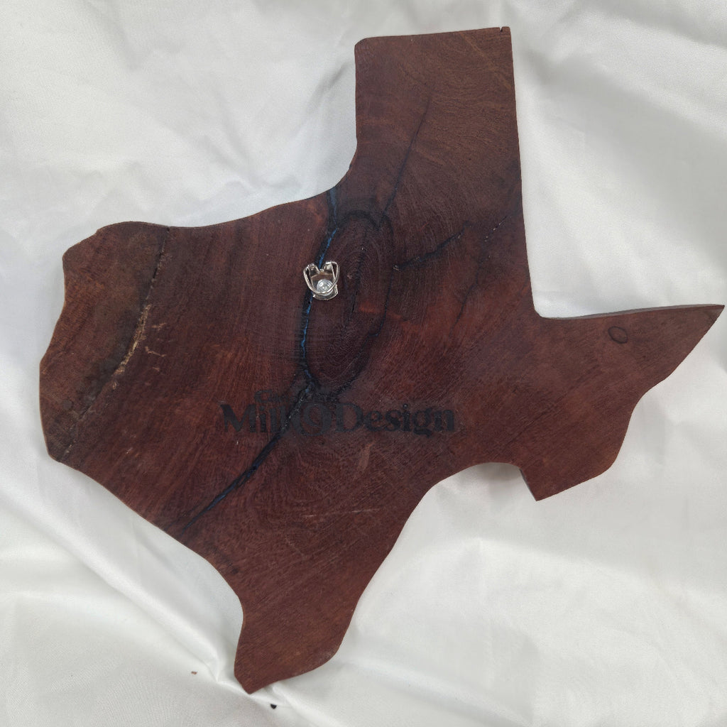 back view A rustic, hand-shaped wooden plaque wall art in the shape of Texas, made from mesquite wood with natural grain, dark burn marks and blue epoxy fill