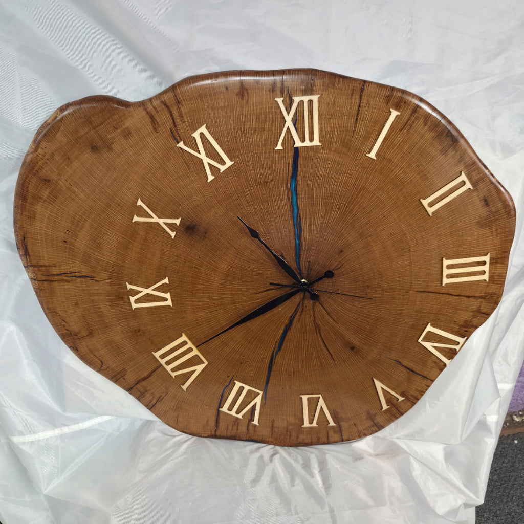 Large live edge Live Oak clock with wooden roman numerals with blue epoxy inlay and black clock arms