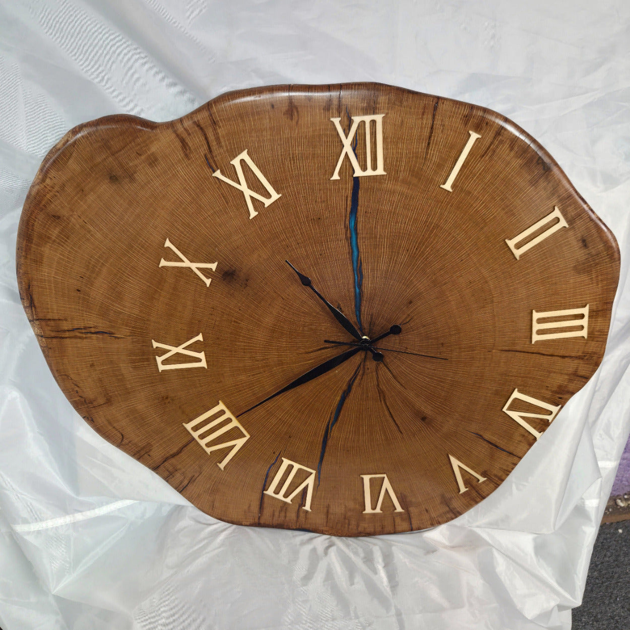 Large live edge Live Oak clock with wooden roman numerals with blue epoxy inlay and black clock arms