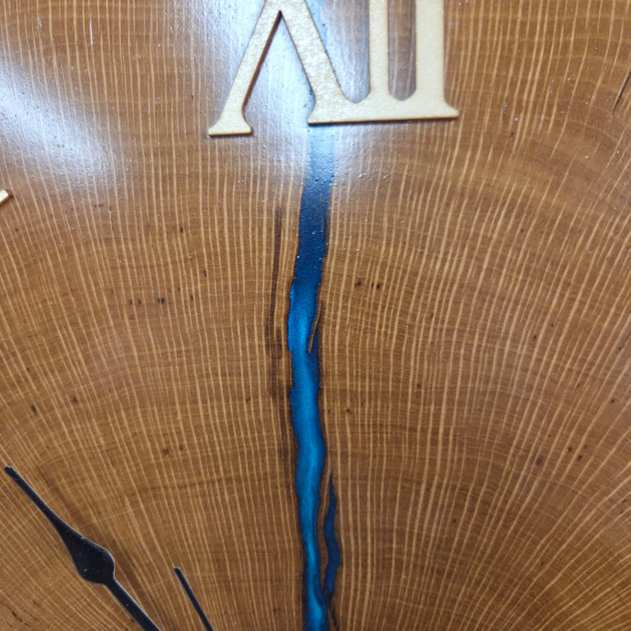 Large live edge Live Oak clock with wooden roman numerals with blue epoxy inlay and black clock arms
