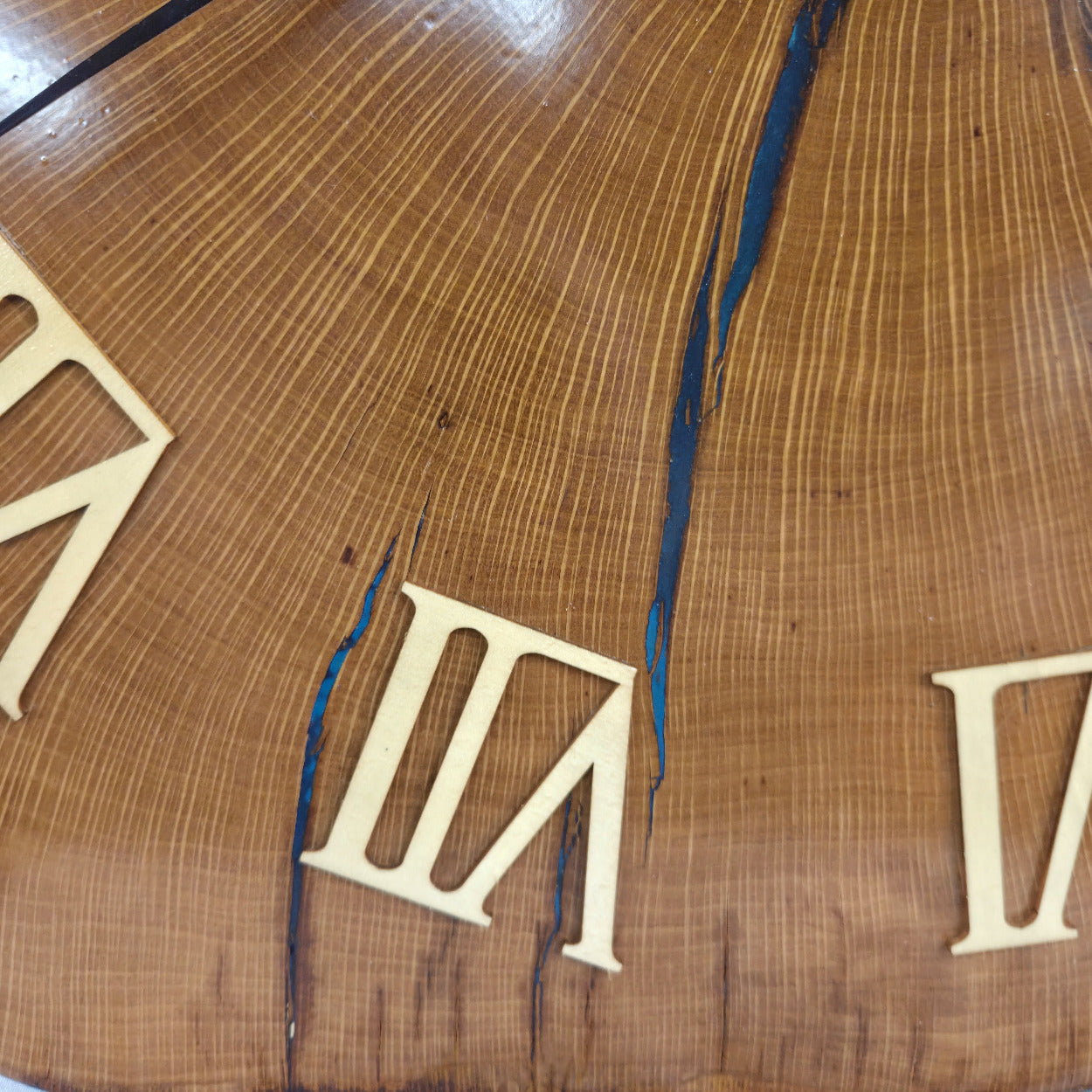 Large live edge Live Oak clock with wooden roman numerals with blue epoxy inlay and black clock arms