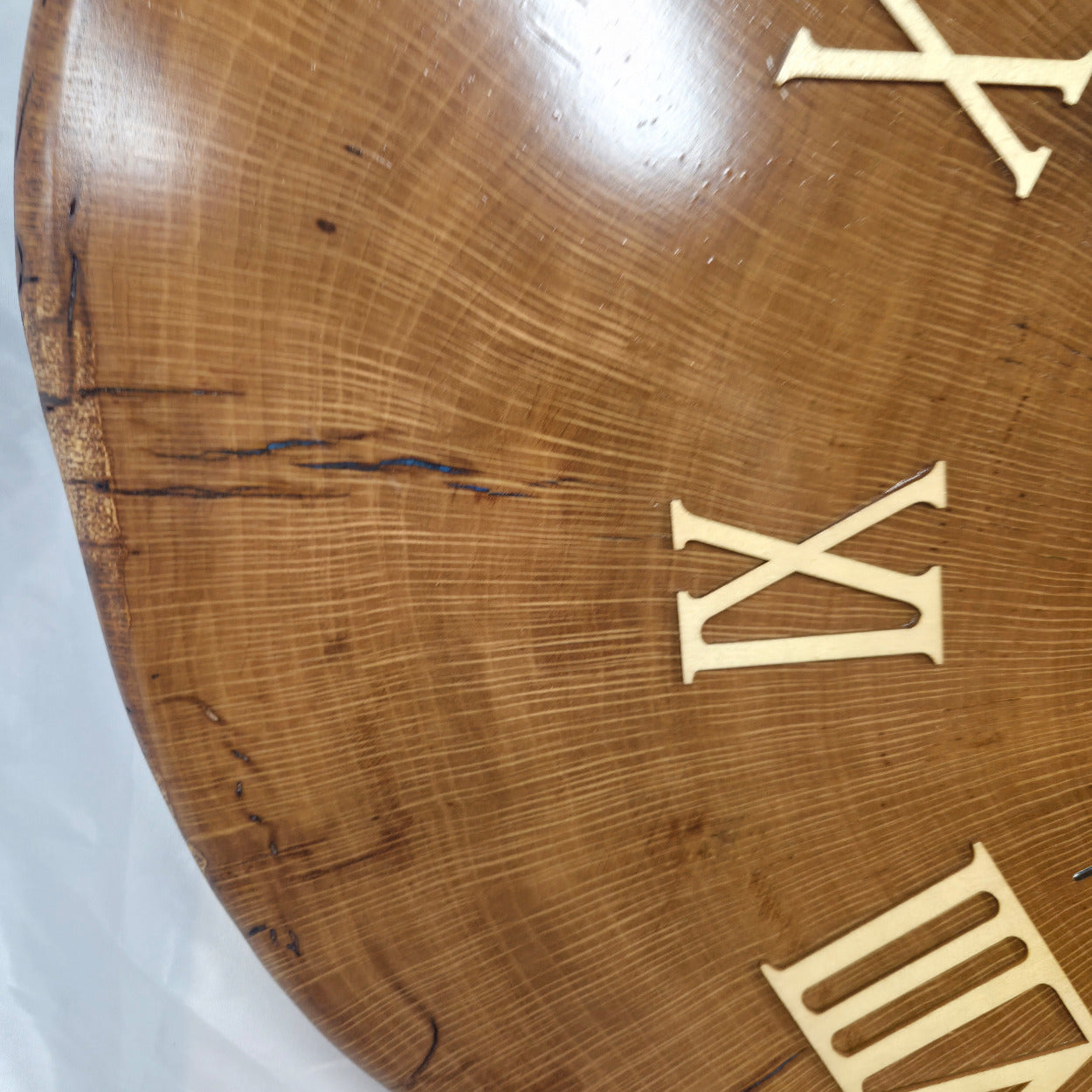 Large live edge Live Oak clock with wooden roman numerals with blue epoxy inlay and black clock arms