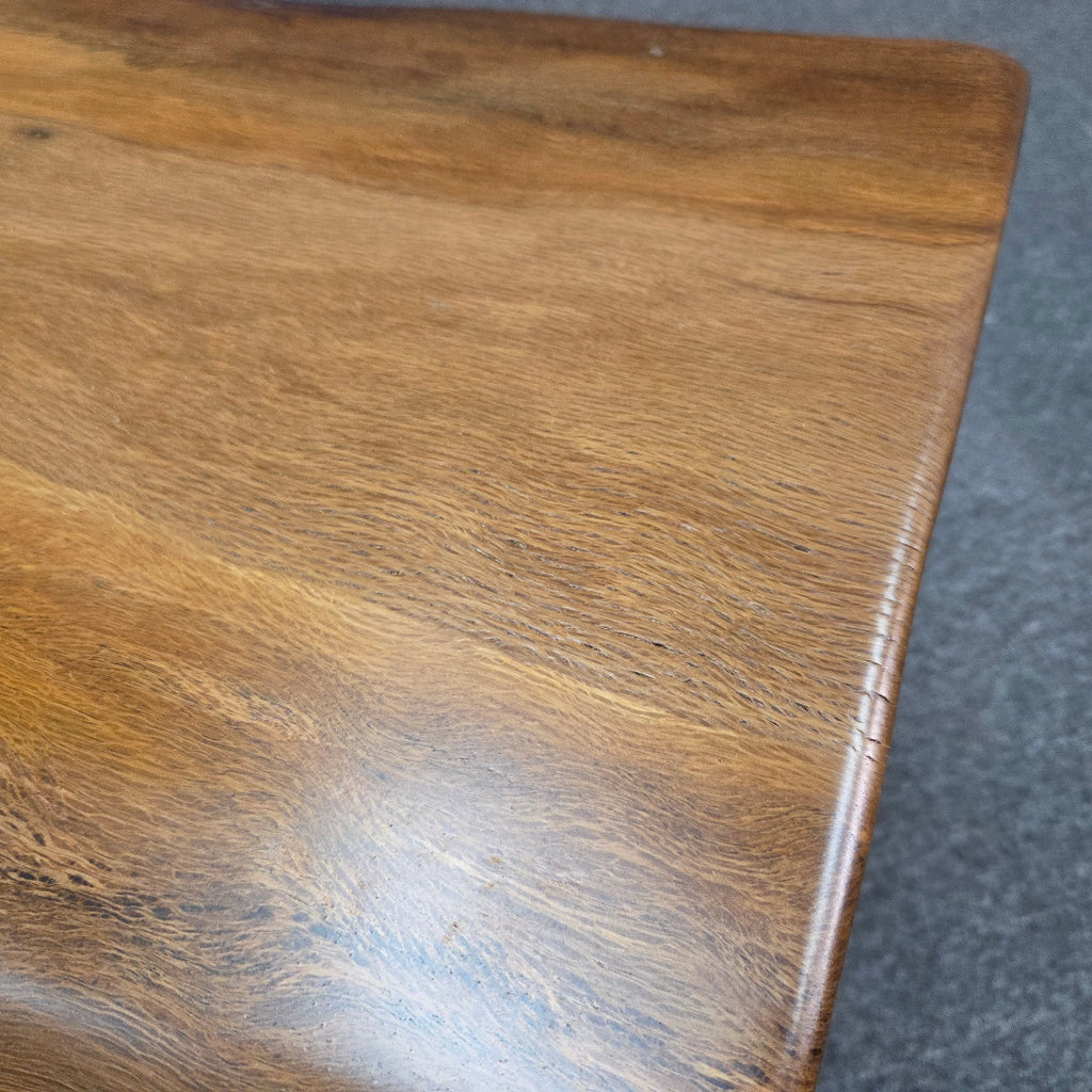 close up A square Live Oak end table with a live-edge natural top and black metal legs, furniture showroom setting on a gray carpet.
