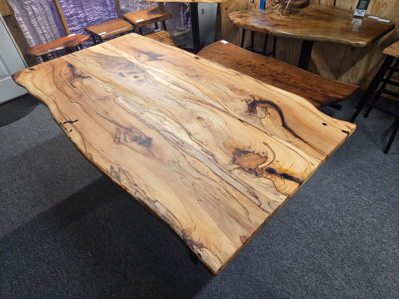 Elm dining table. live edge with rustic feel on black x-style metal legs