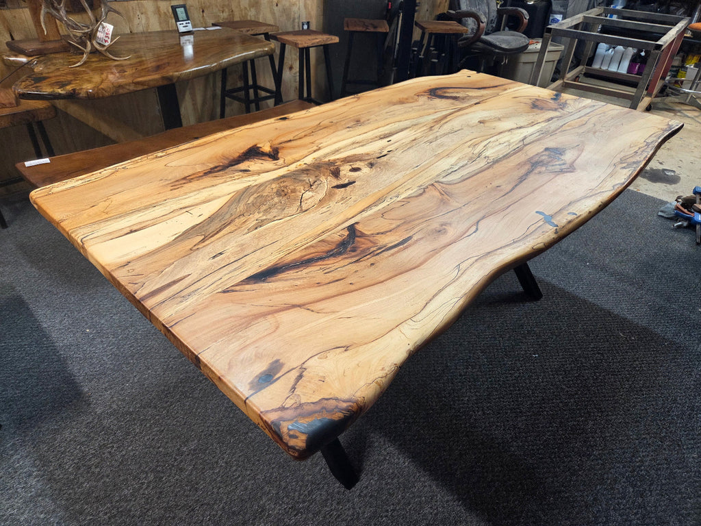 Elm dining table. live edge with rustic feel on black x-style metal legs