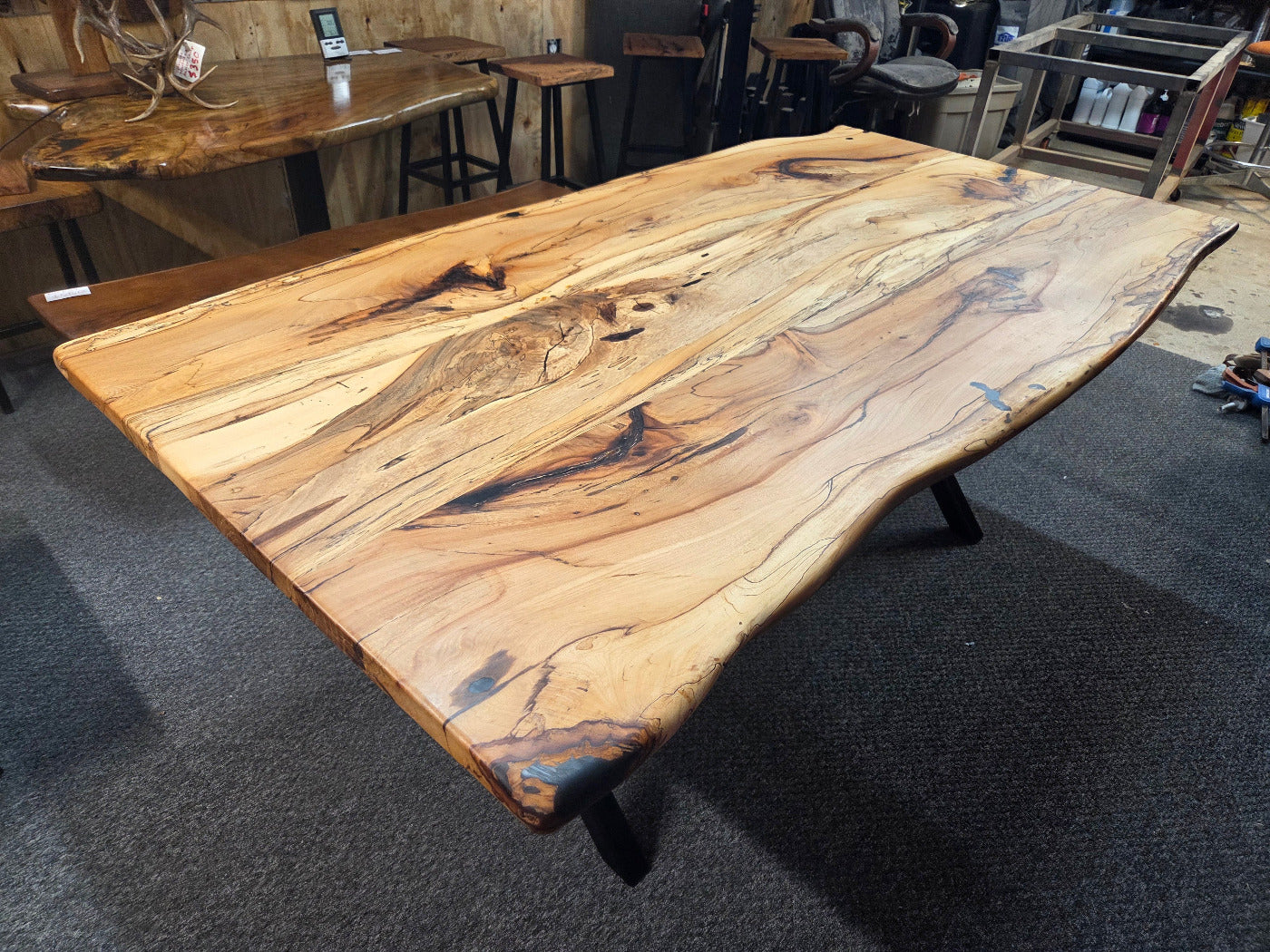 Elm dining table. live edge with rustic feel on black x-style metal legs