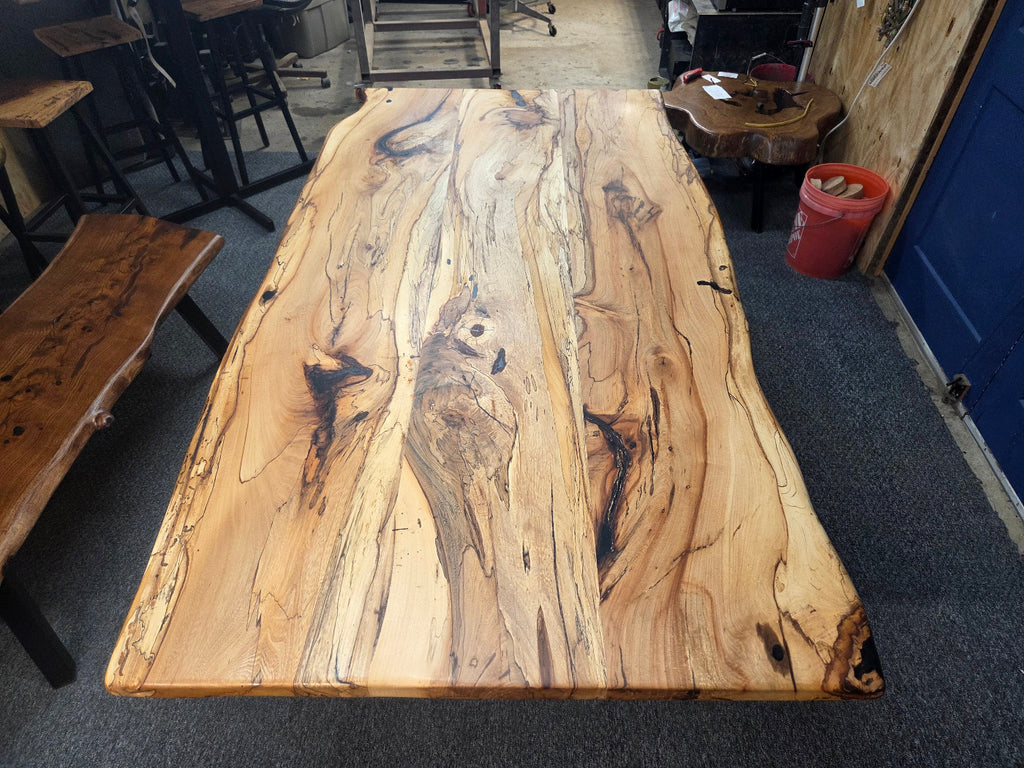 Elm dining table. live edge with rustic feel on black x-style metal legs