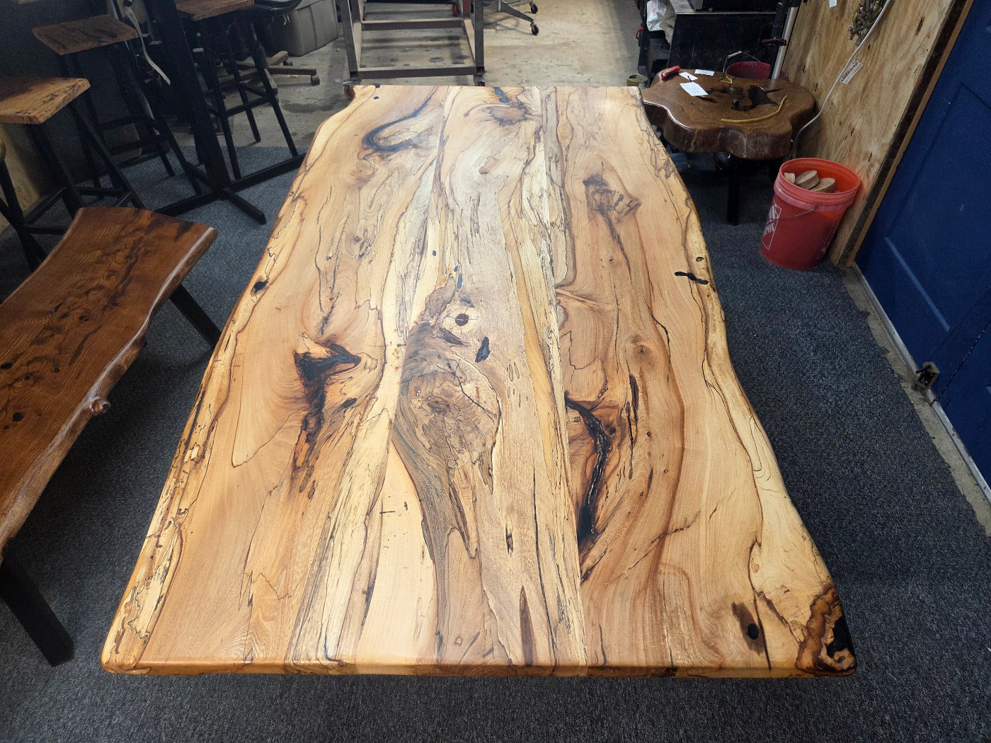 Elm dining table. live edge with rustic feel on black x-style metal legs