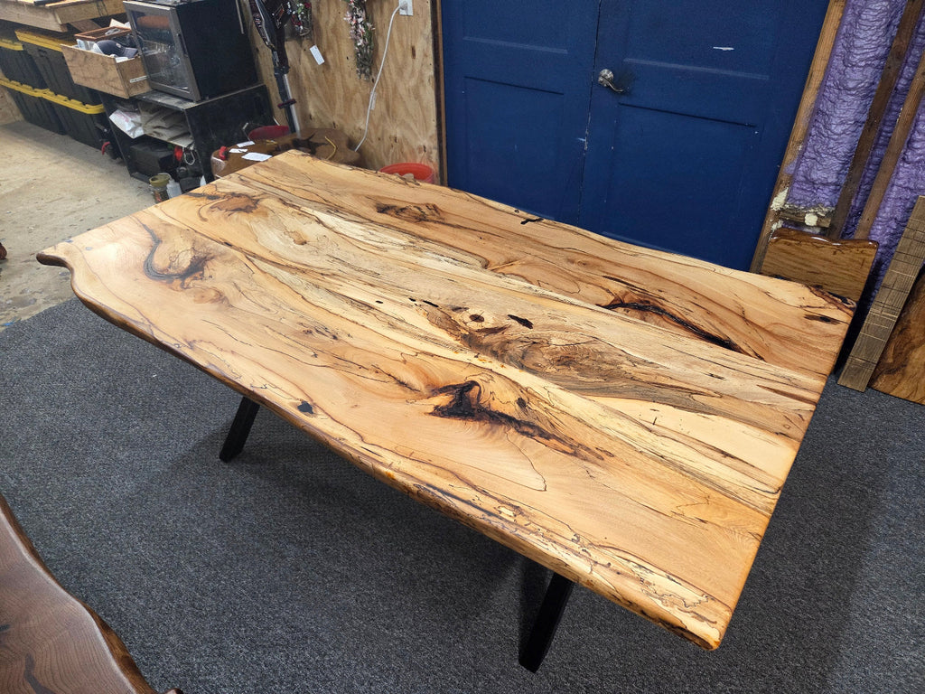 Elm dining table. live edge with rustic feel on black x-style metal legs