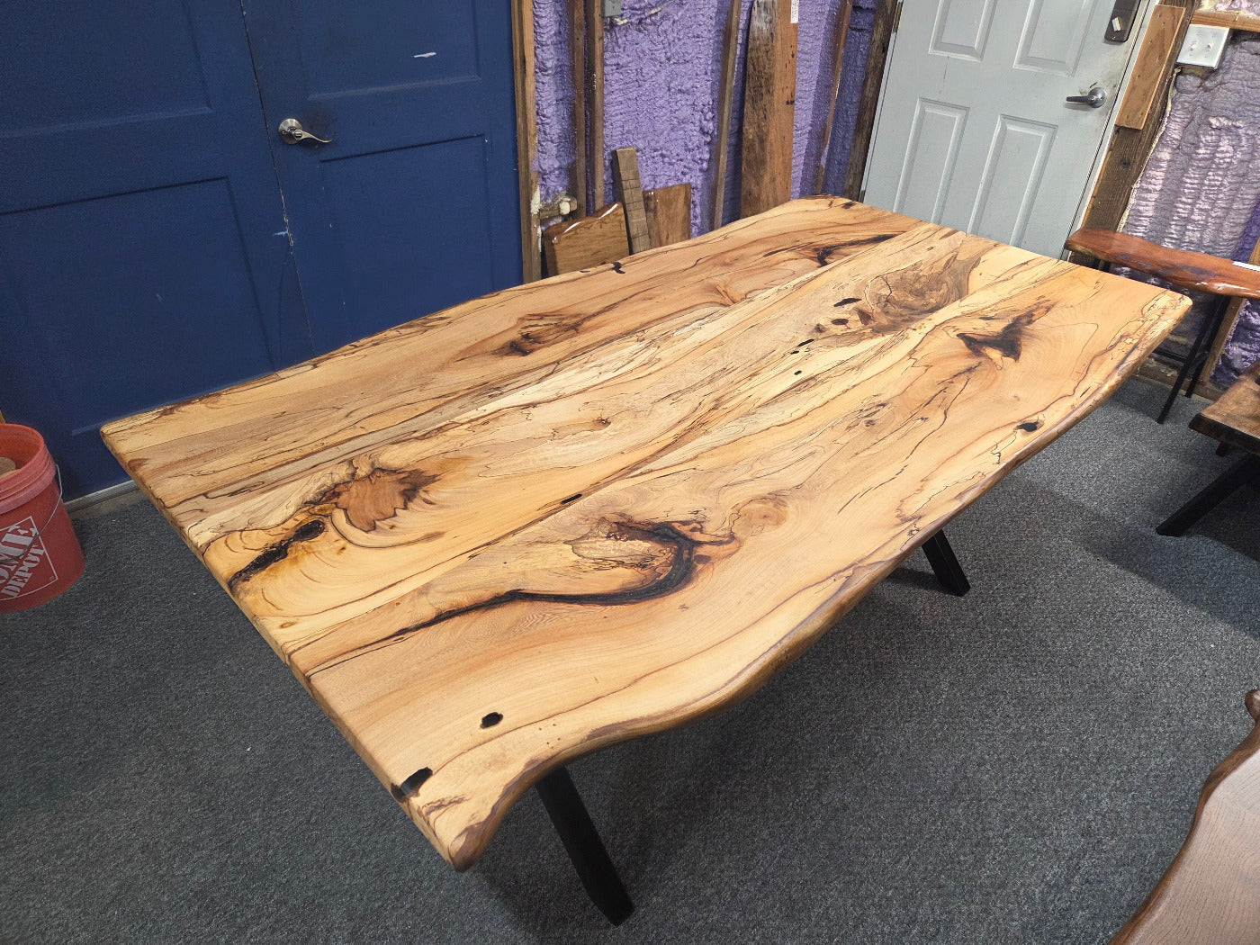 Elm dining table. live edge with rustic feel on black x-style metal legs