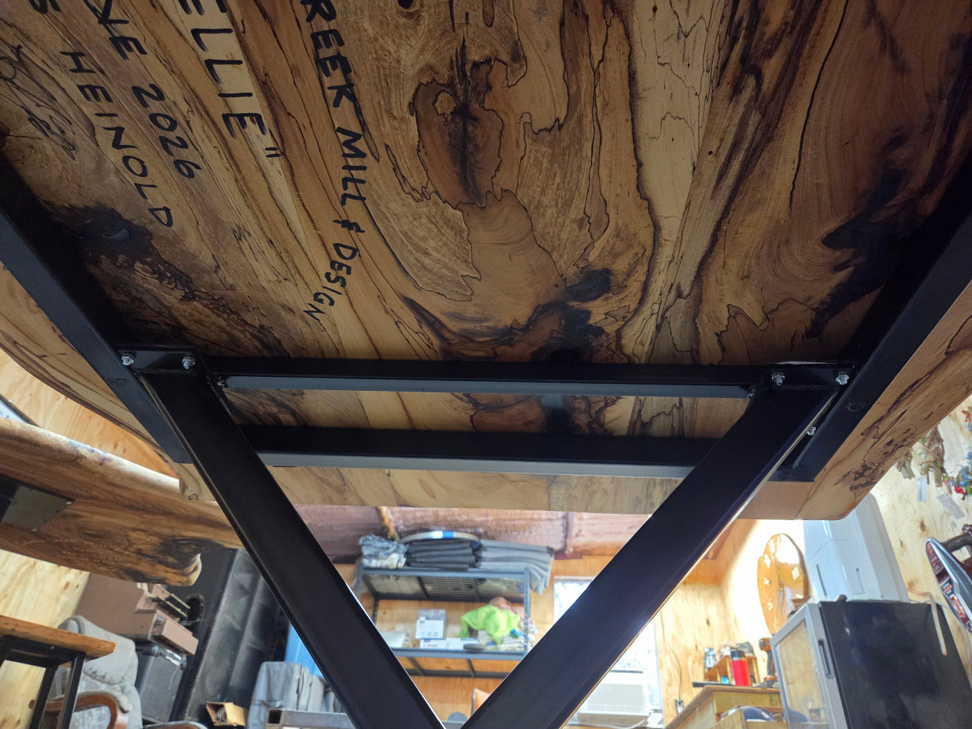 Elm dining table. live edge with rustic feel on black x-style metal legs
