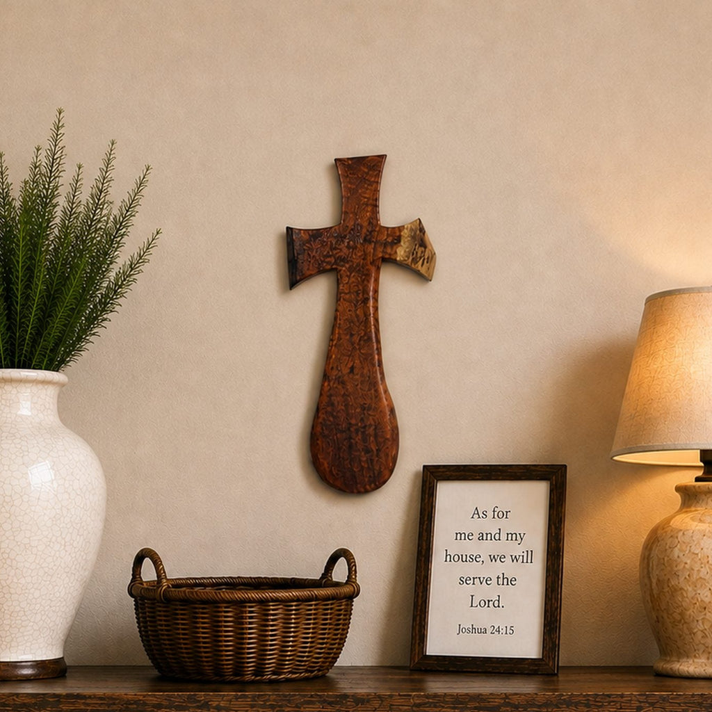 A rustic dark wood console table styled in a warm home interior, featuring a large white ceramic vase with green foliage, a brown wicker basket, a framed scripture print, and a lit table lamp with a beige shade.
