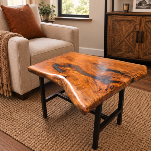 A rustic live-edge wooden coffee table with a glossy, polished surface showing rich natural grain and dark resin pockets, supported by a black metal frame. The table is styled in a cozy living room setting next to a beige armchair and on a woven jute rug.