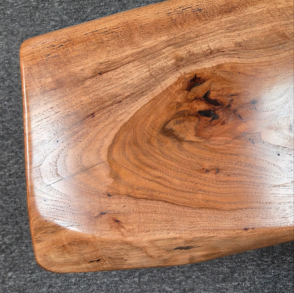 closeup view Handcrafted live edge pecan coffee table with Honey Oak stain and black steel legs