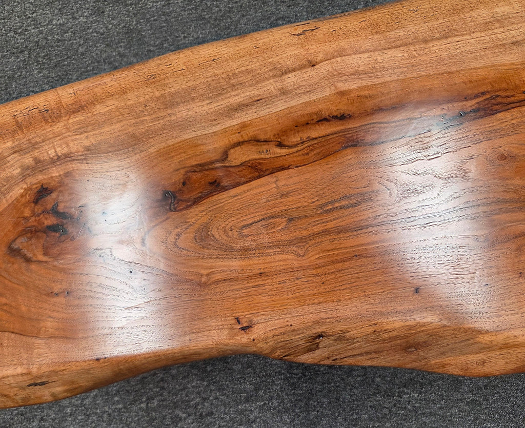 closeup view Handcrafted live edge pecan coffee table with Honey Oak stain and black steel legs