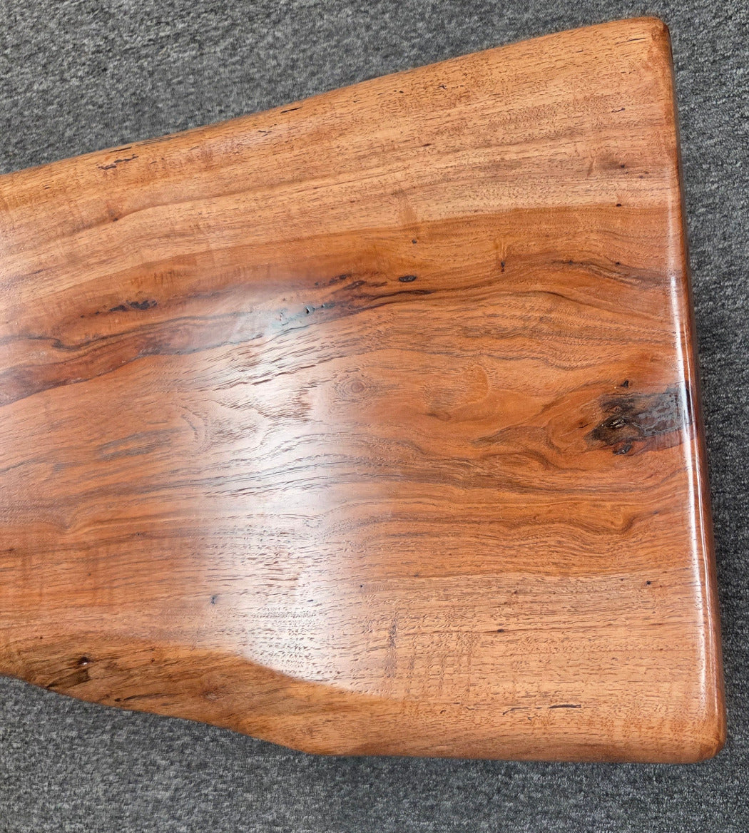 closeup view Handcrafted live edge pecan coffee table with Honey Oak stain and black steel legs