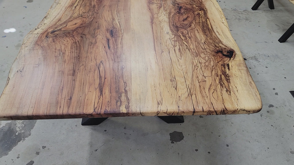 A large live-edge Pecan dining table with matching bench seats, in the natural color with x-style black metal legs