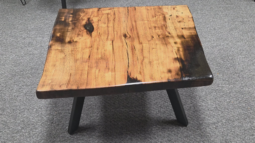 Pecan coffee table with a rustic finish and sho sugi bon treatment with black metal legs